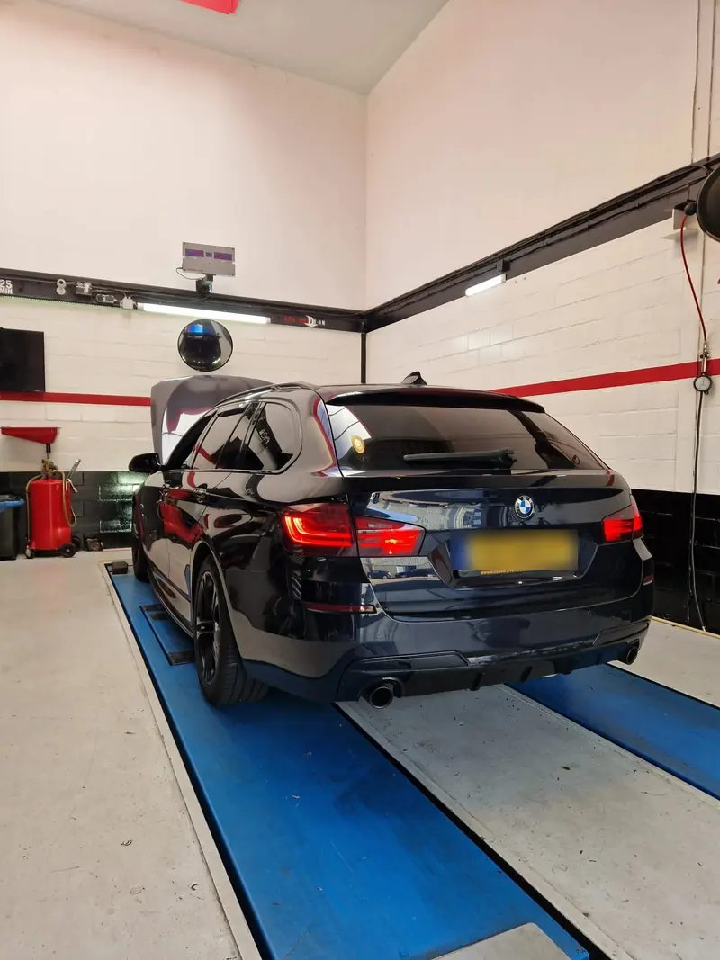 BMW in de APK-keuringsstraat van APK DRIVE-IN met geopende motorkap